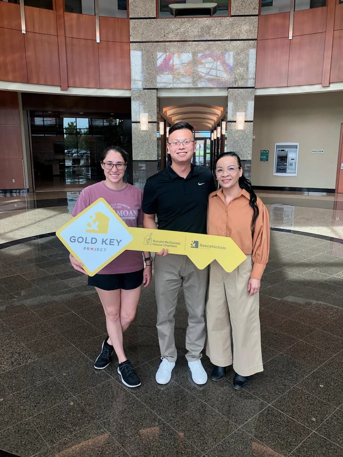 A family holding the Gold Key sign after closing