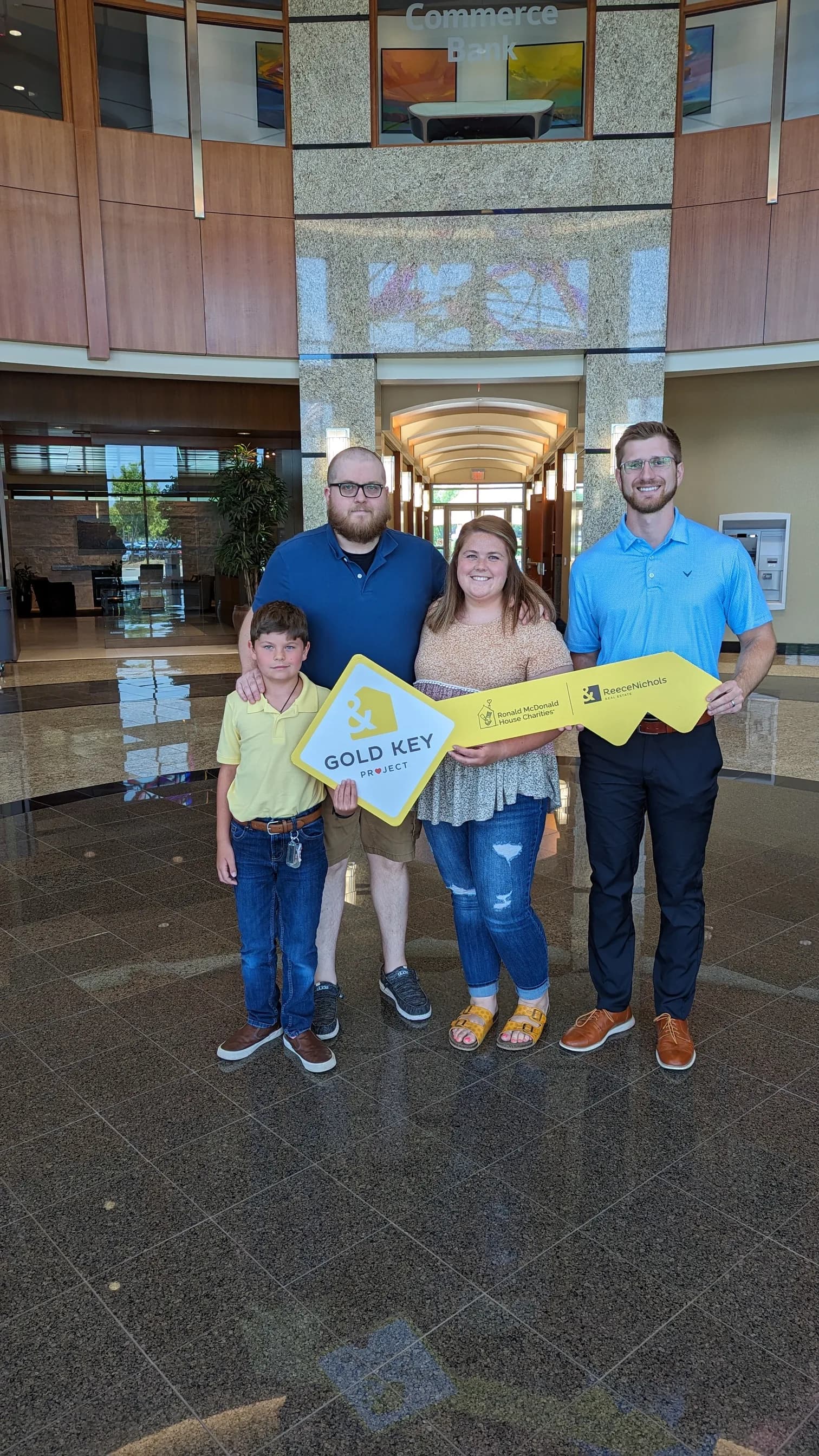 A family celebrating closing day with the Gold Key sign