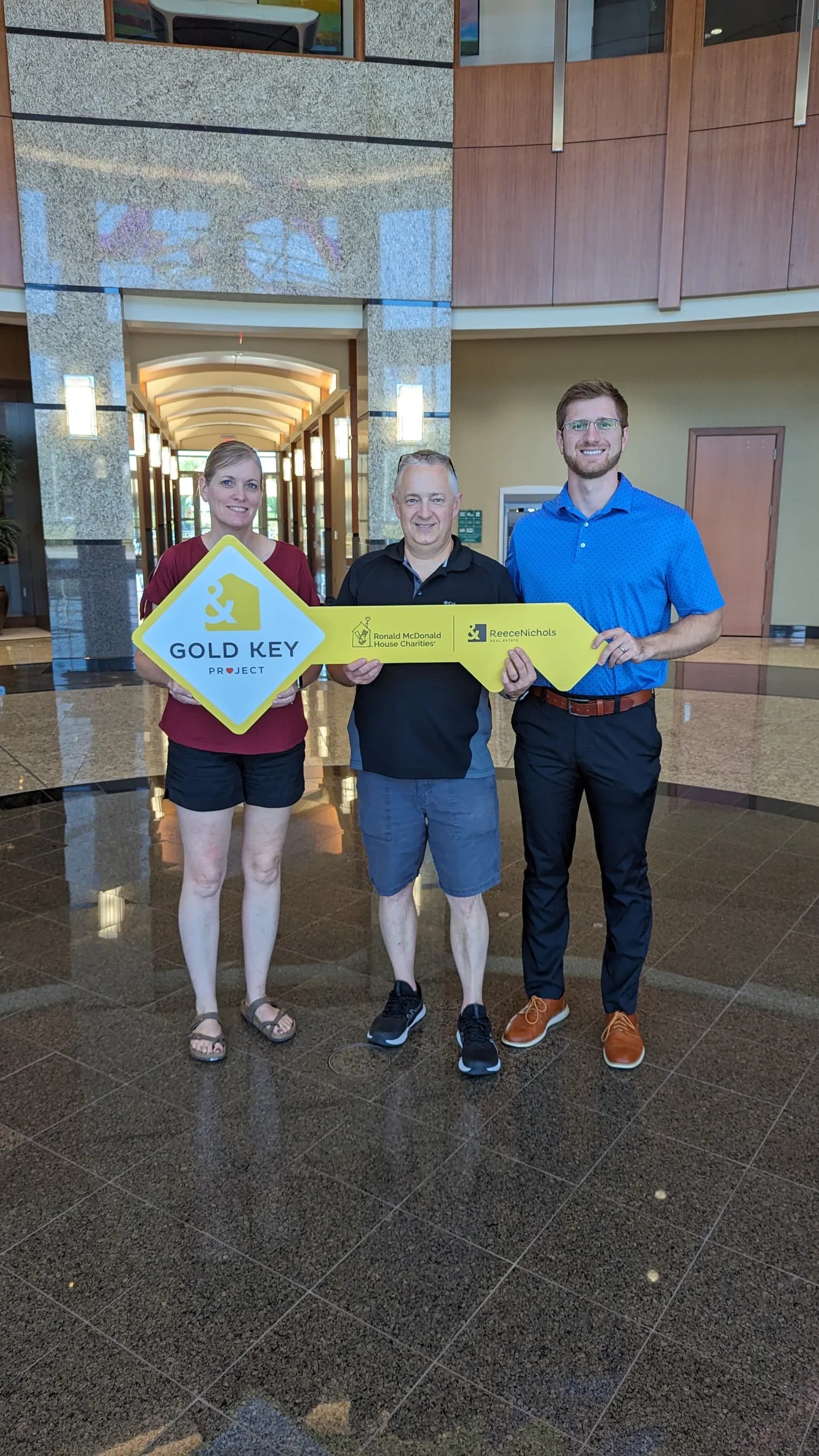 Clients holding the Gold Key sign after closing