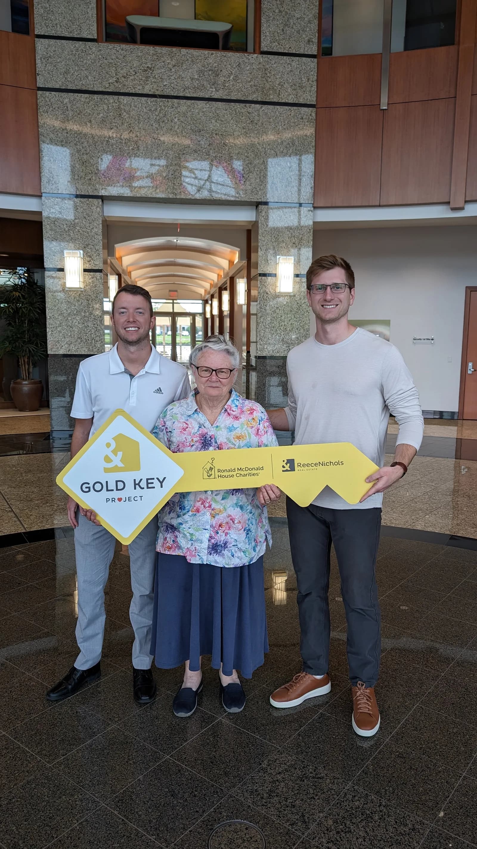 Clients holding the Gold Key sign at closing