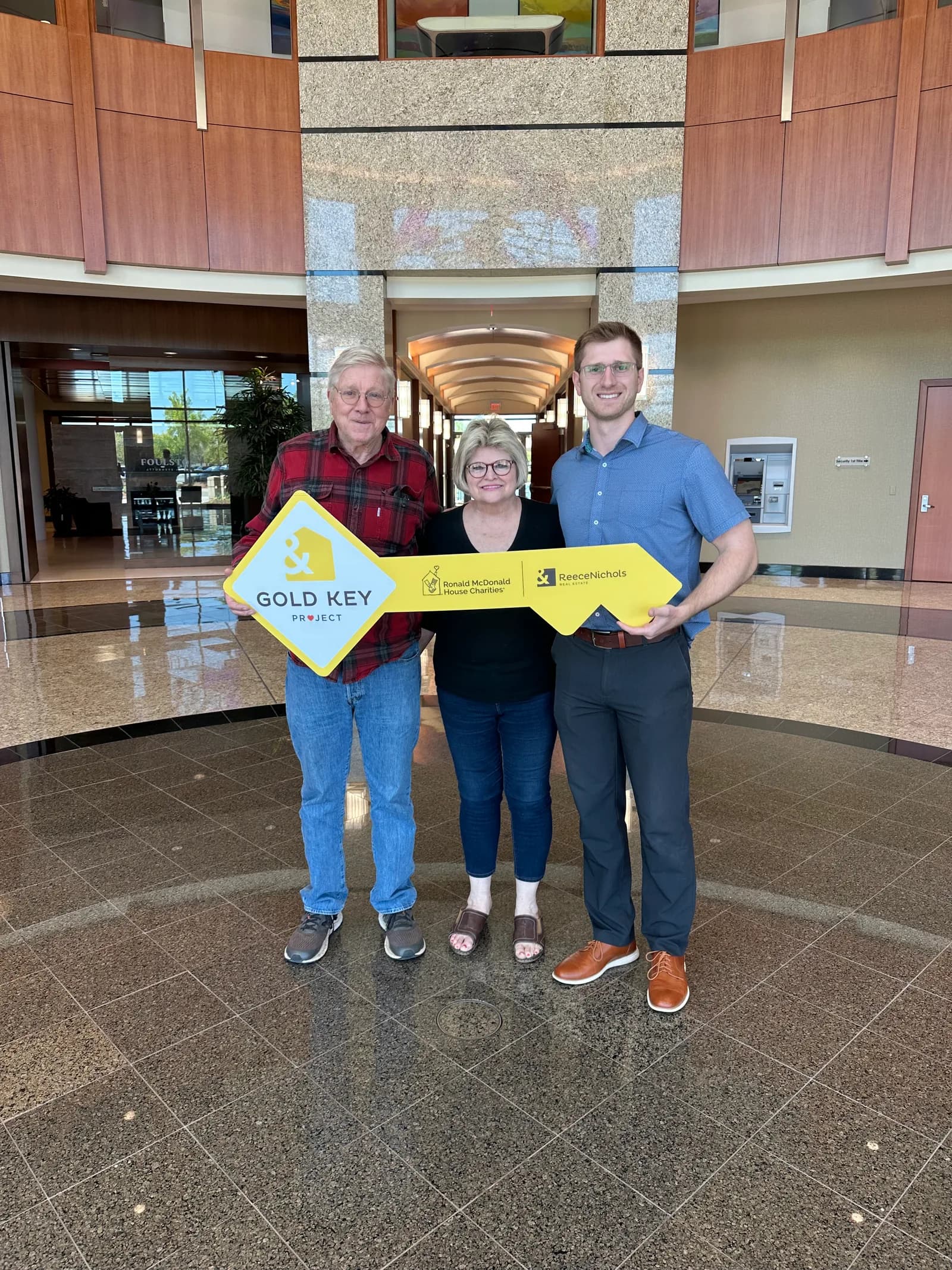 Clients holding the Gold Key sign after closing