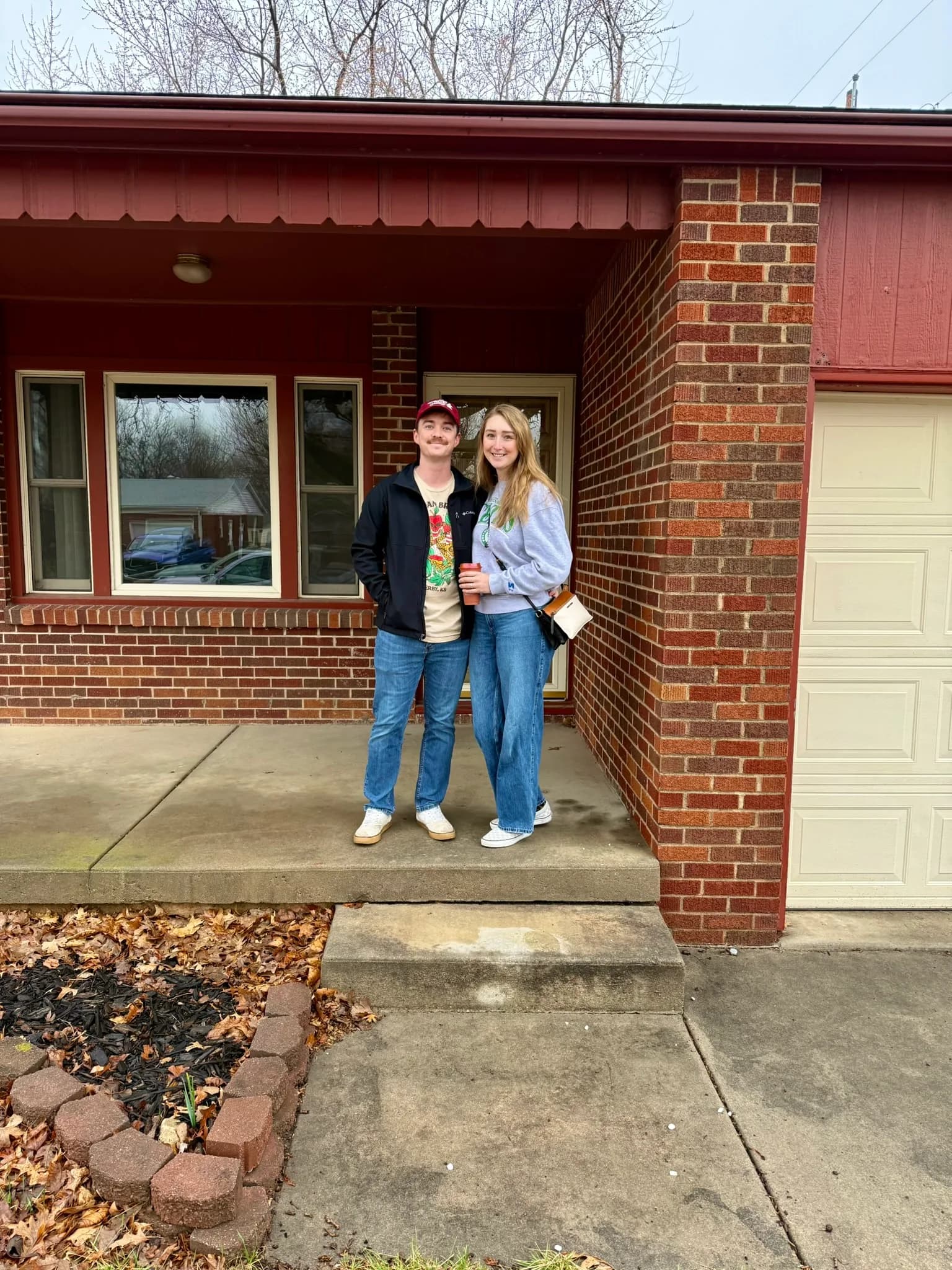 A couple outside their new brick home