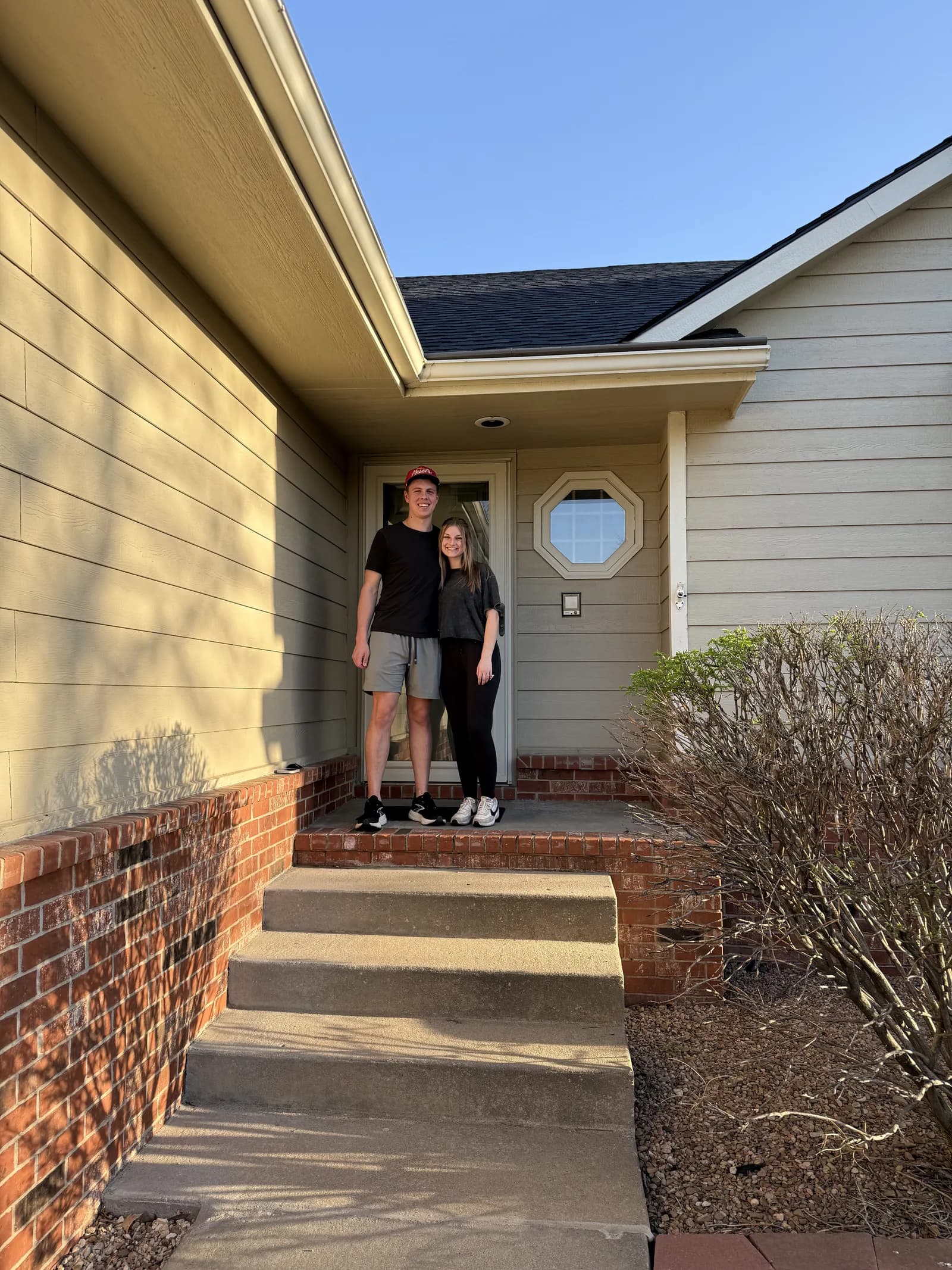 A young couple on the porch of their new home