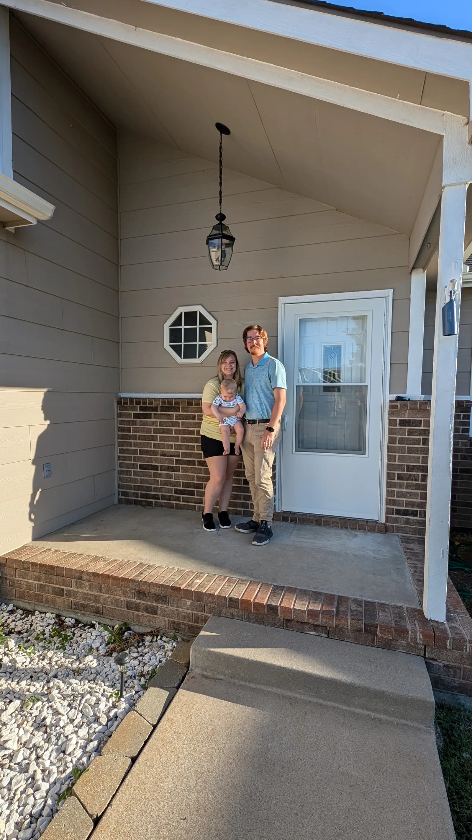 A young family on the porch of their new home