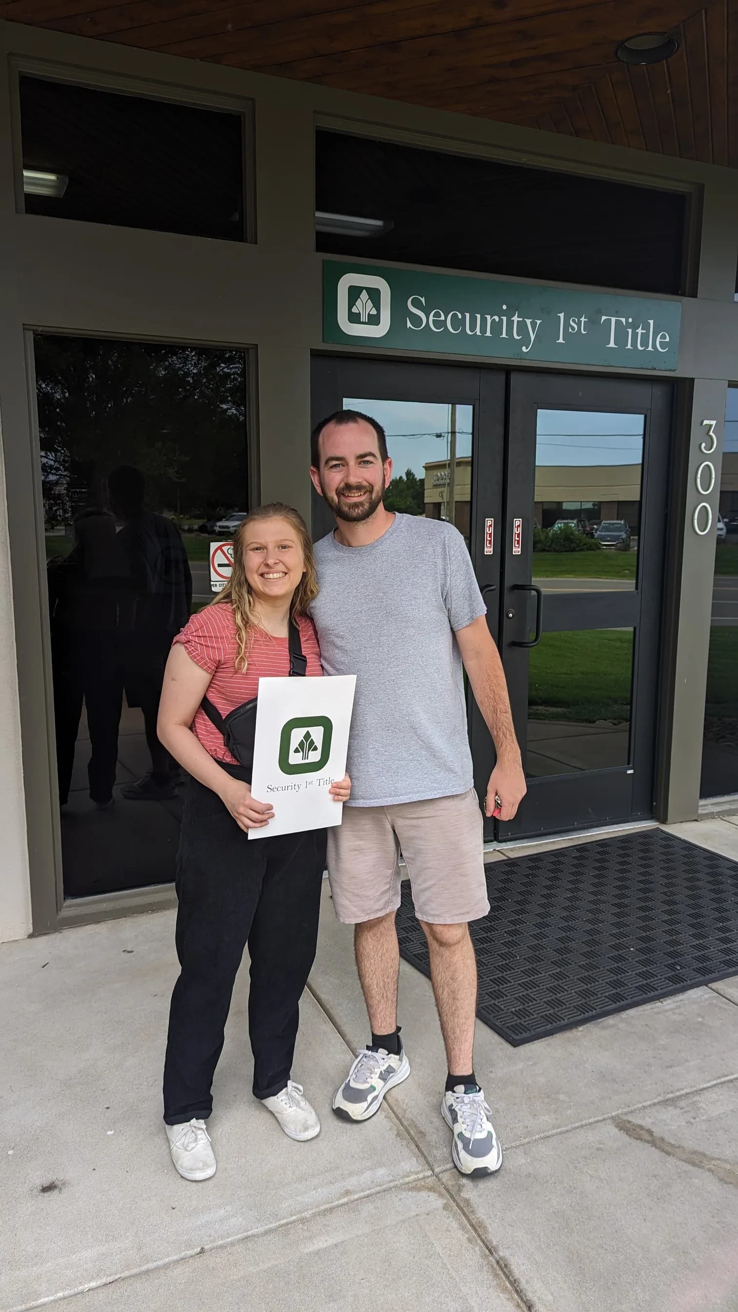 Clients holding their closing papers outside the title company