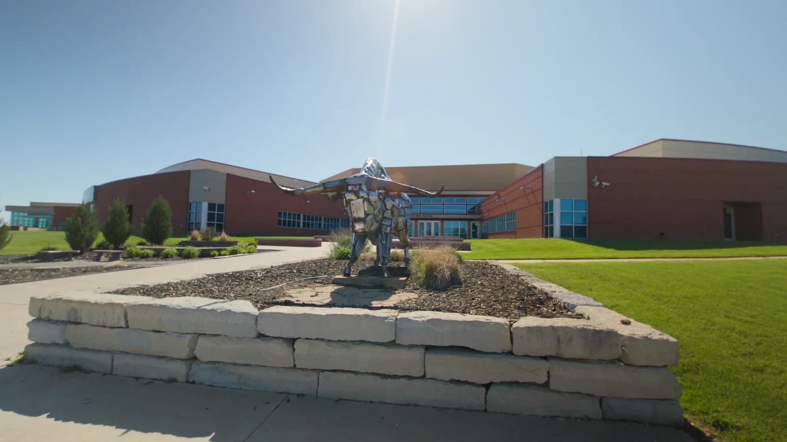 Steer statue on a stone planter outside Maize South High School